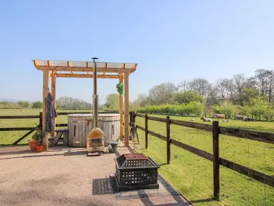 a gazebo with a grill in a field at Balwen Shepherd's Hut in Montgomery