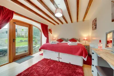 a bedroom with a bed with a red blanket at 4 Bed in Llanarmon Dyffryn Ceiriog oc-bow151 in Llanarmon Dyffryn-Ceiriog