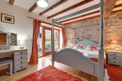 a bedroom with a bed and a stone wall at 4 Bed in Llanarmon Dyffryn Ceiriog oc-bow151 in Llanarmon Dyffryn-Ceiriog