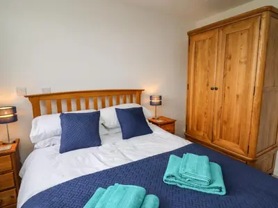 a bedroom with a bed with blue towels on it at Gwynant in Ystrad Meurig
