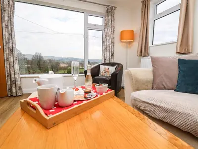a living room with a tray of food on a table at Gwynant in Ystrad Meurig